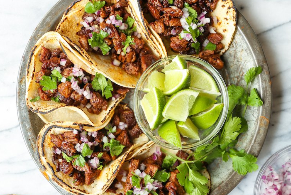 5 meaty tacos garnished with onions and cilantro and lime wedges