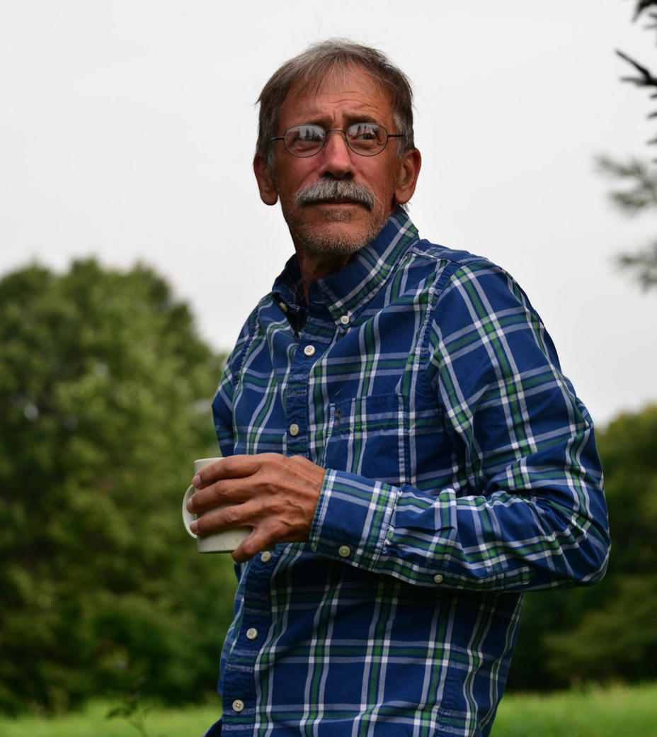 a man with a mustache hodling a mug