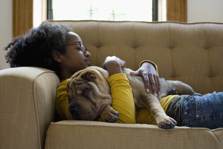 girl and a sharpay puppy sleep on a couch