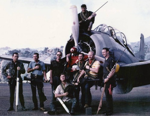 a group of ragtag soldiers posing in front of a plane