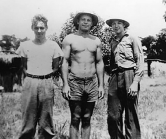 three people standing in a grassy field