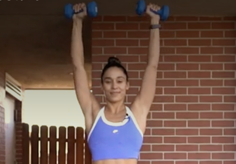 person pressing the weights overhead, rotating palms away from body.