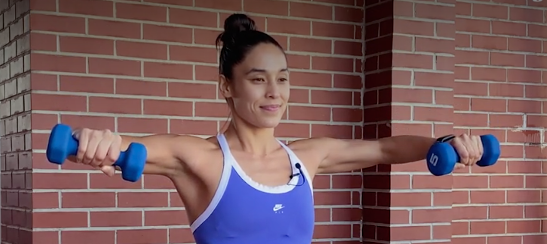 standing with dumbbells in each hand, elbows bent 90 degrees, in line with shoulders, and dumbbells raised to head height