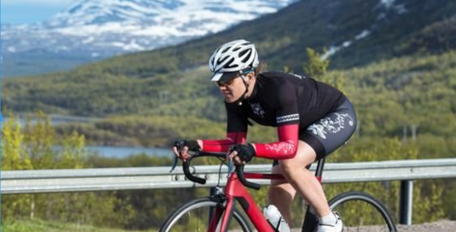 person on a bike alongside mountain scenery