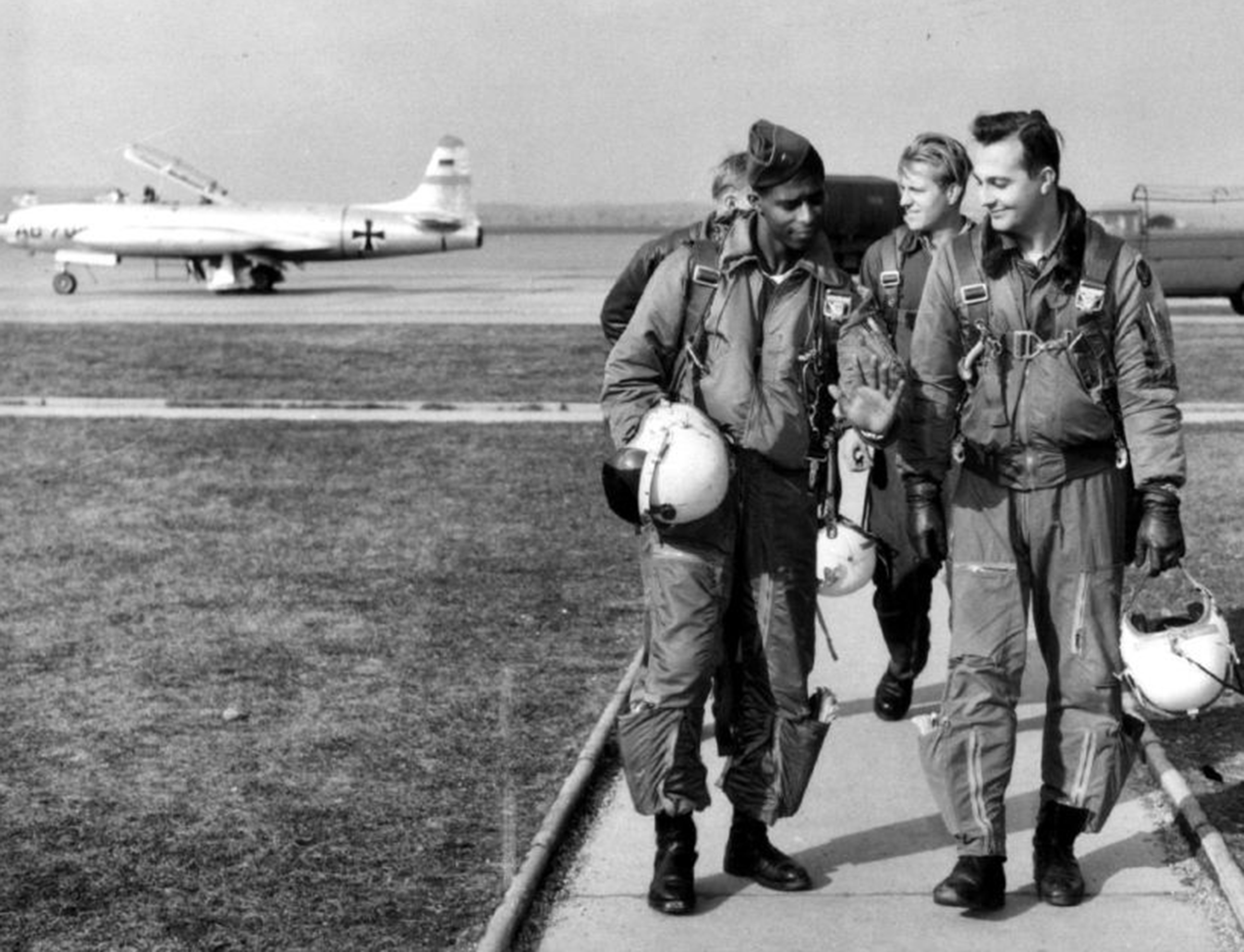 men walking off a runway, jets behind them