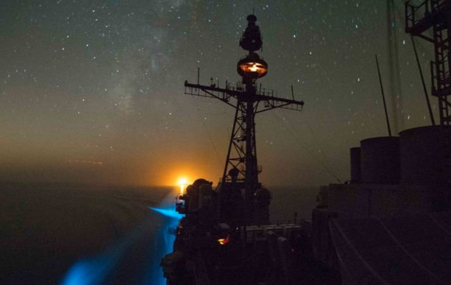 a large ship on the ocean beneath a starry sky