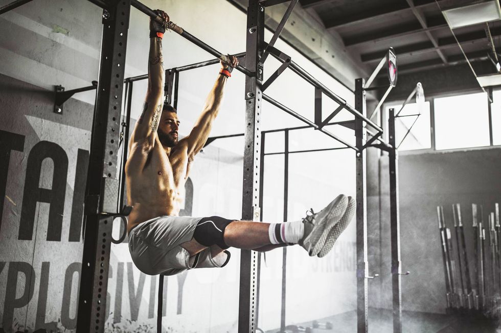 a person holding onto a bar while lifting their legs at a 90-degree angle