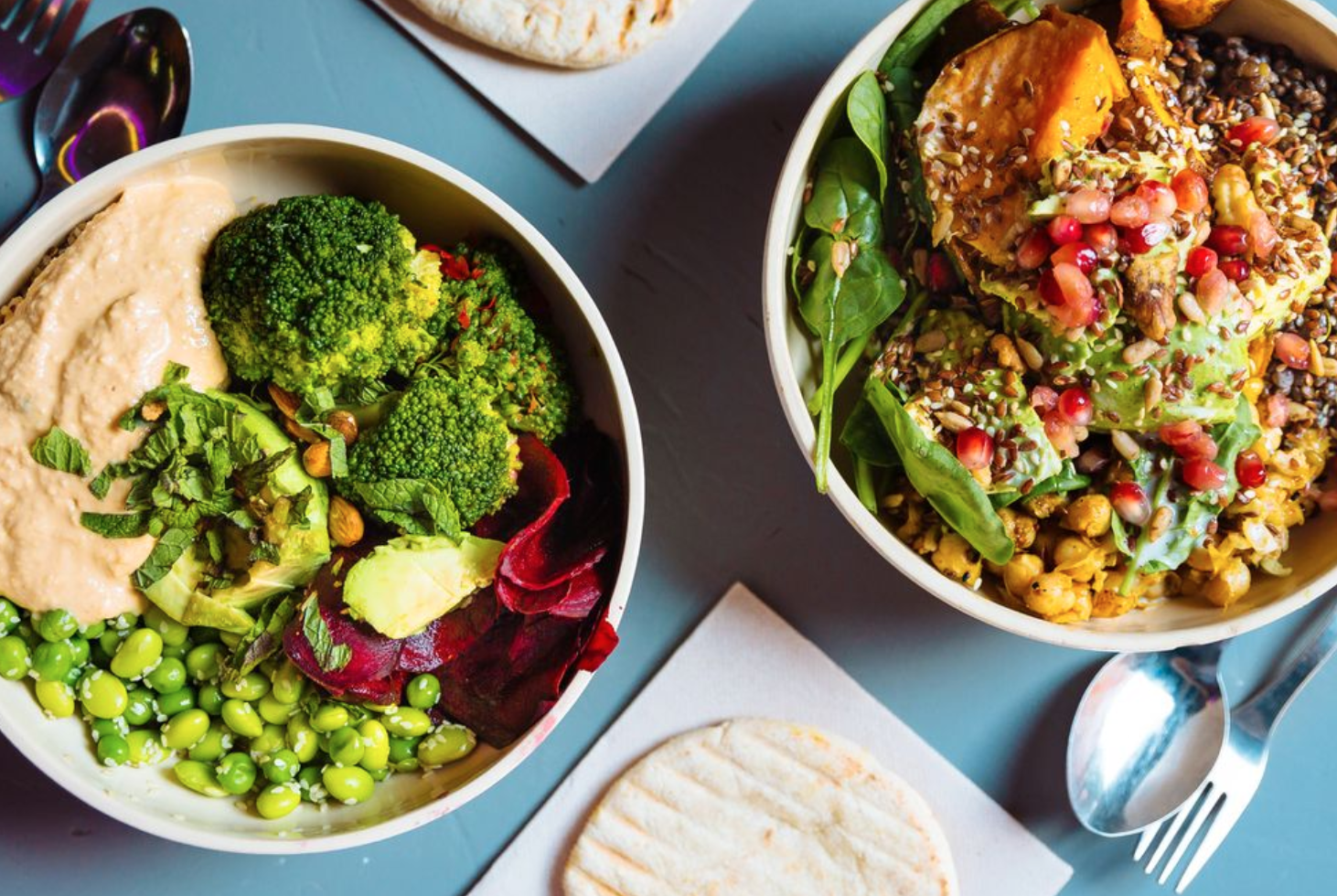 two bowls filled with grains and greens and beans/legumes