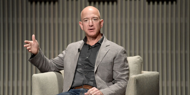 a man sitting in a chair on a stage, speaking