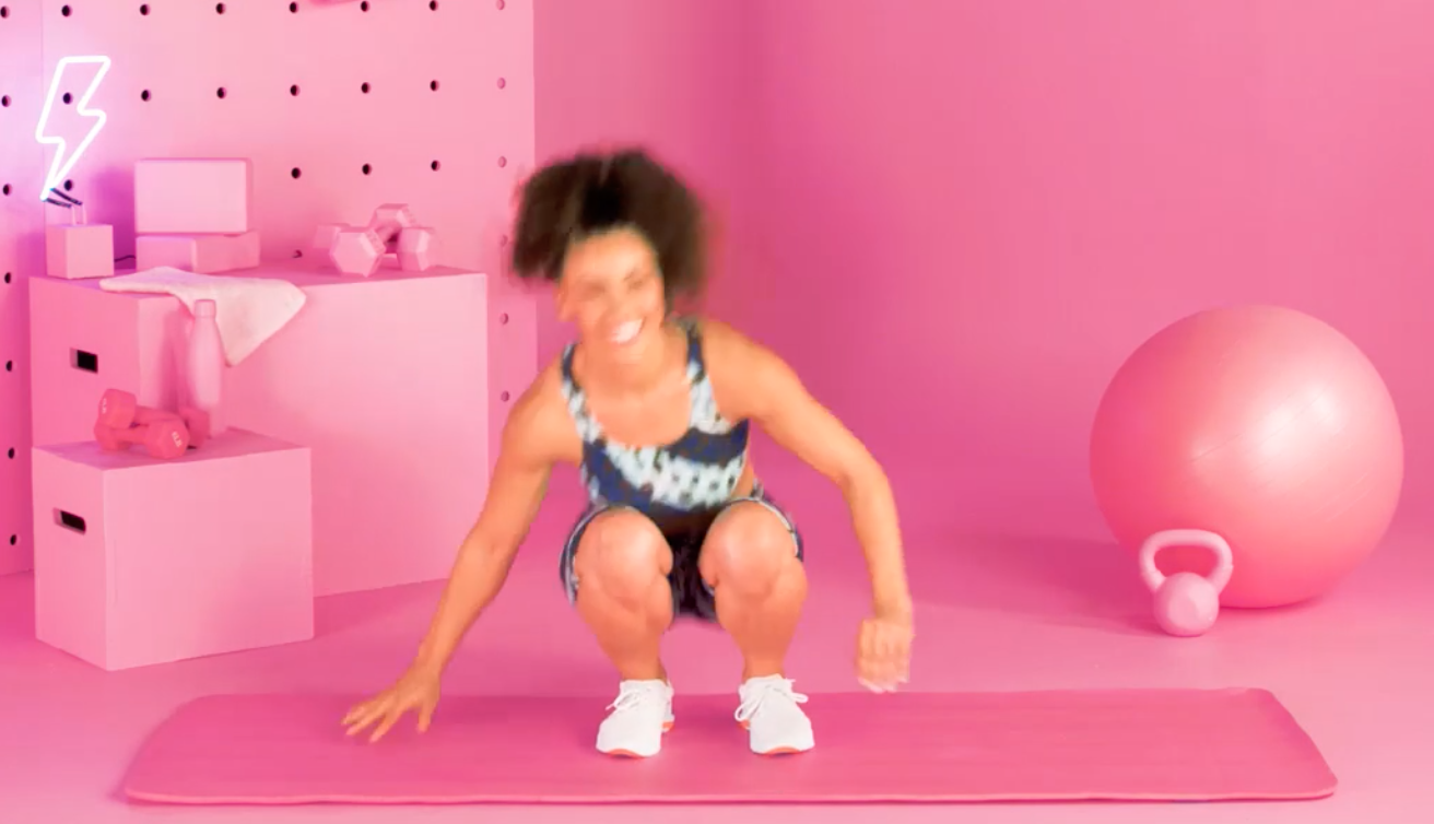 a person doing burpees in a pink room