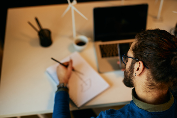 person sitting at a desk, sketching