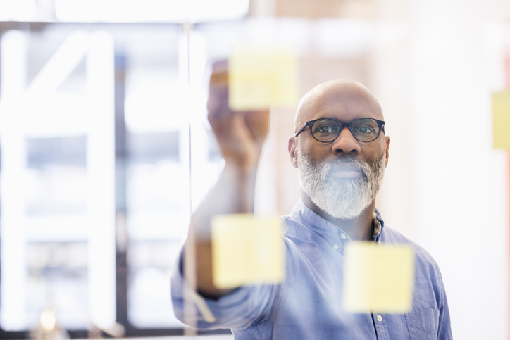 person writing on post-it notes