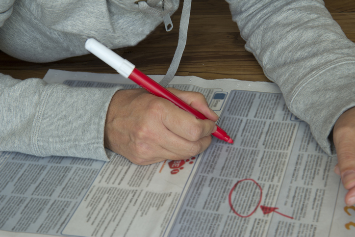 person circling jobs in a newspaper