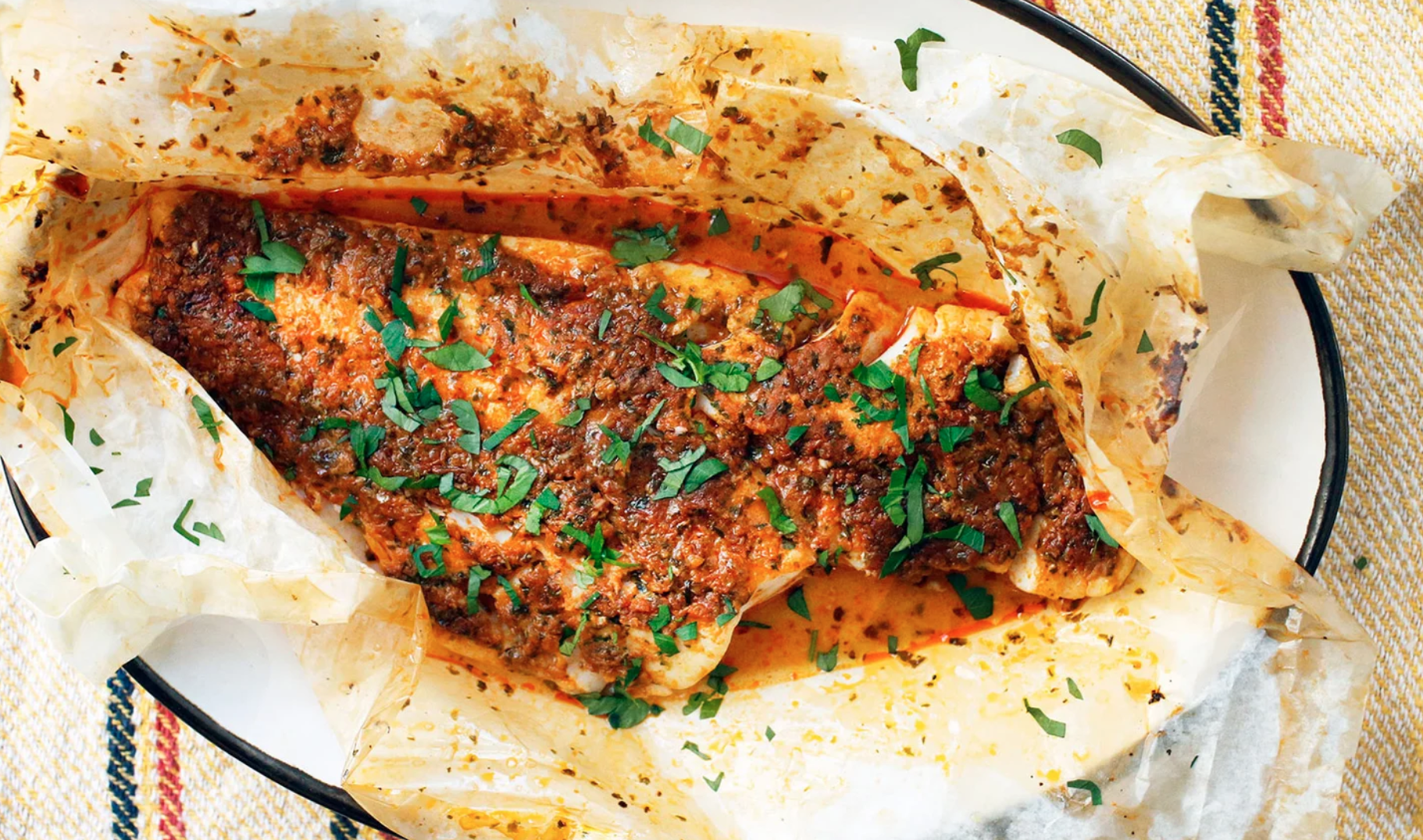 fish in parchment paper, garnished with herbs and spices