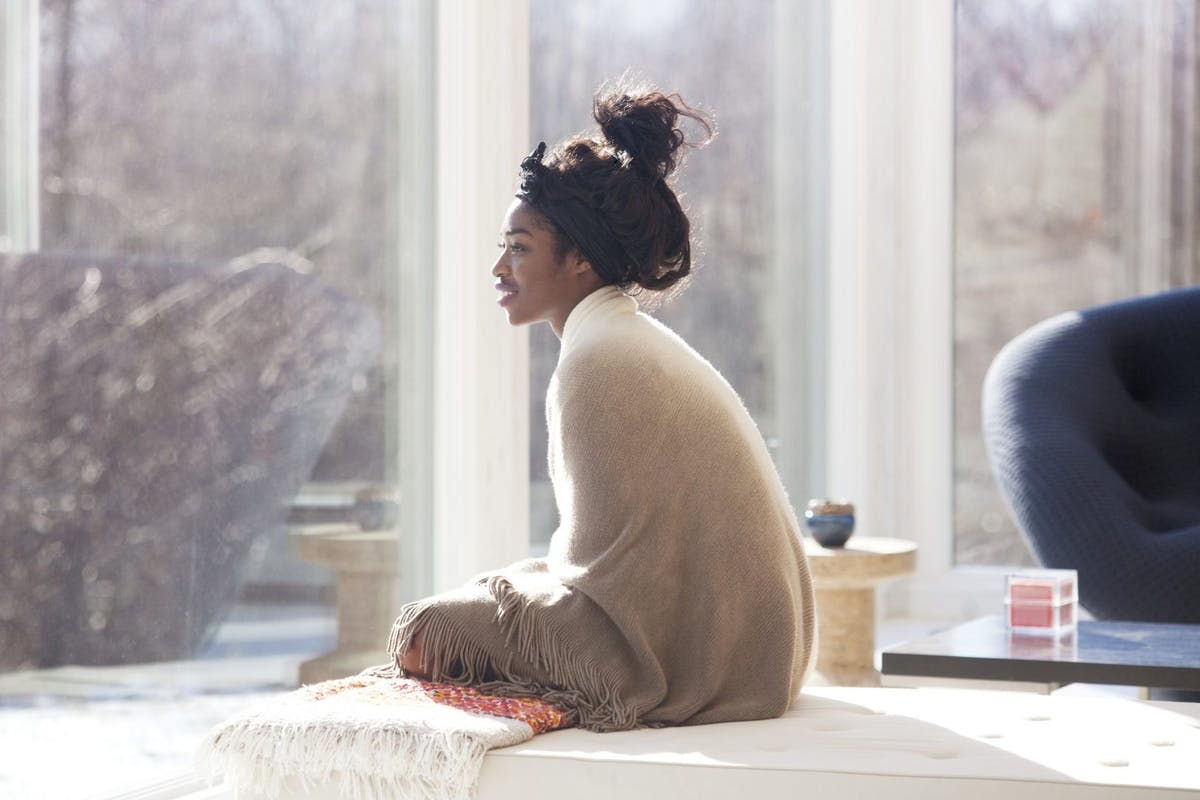 woman bundled up looking out the window