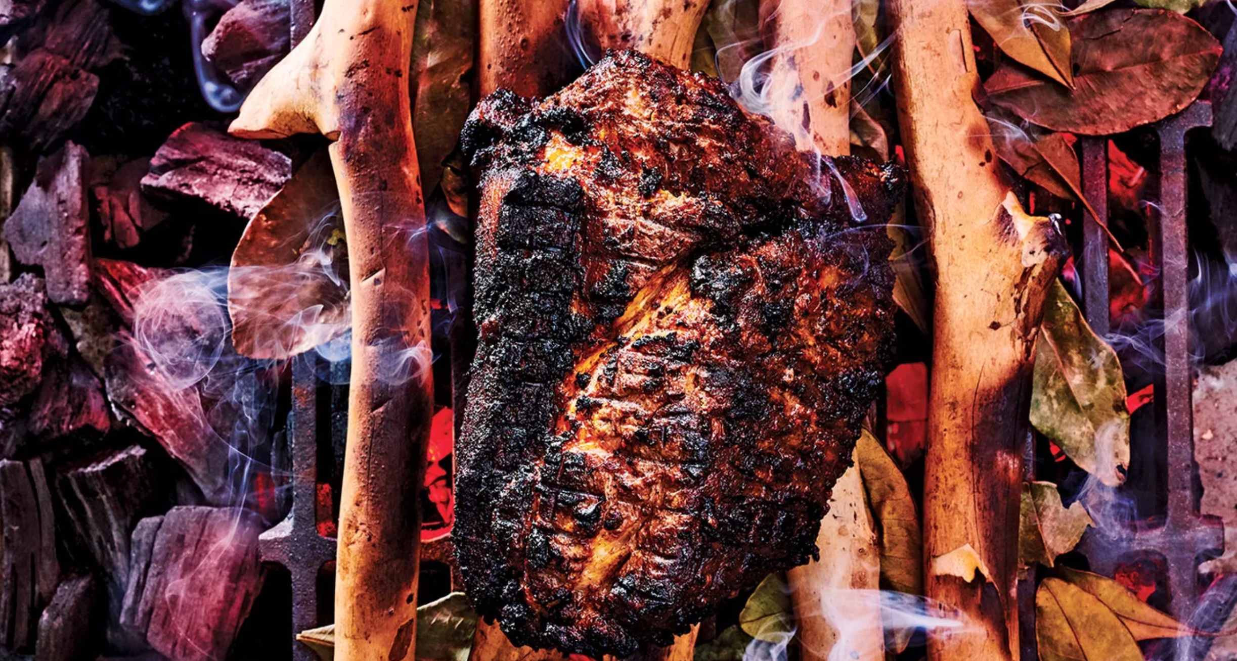 meat on a grill alonside branches