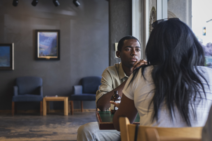 two people at a table in serious conversation