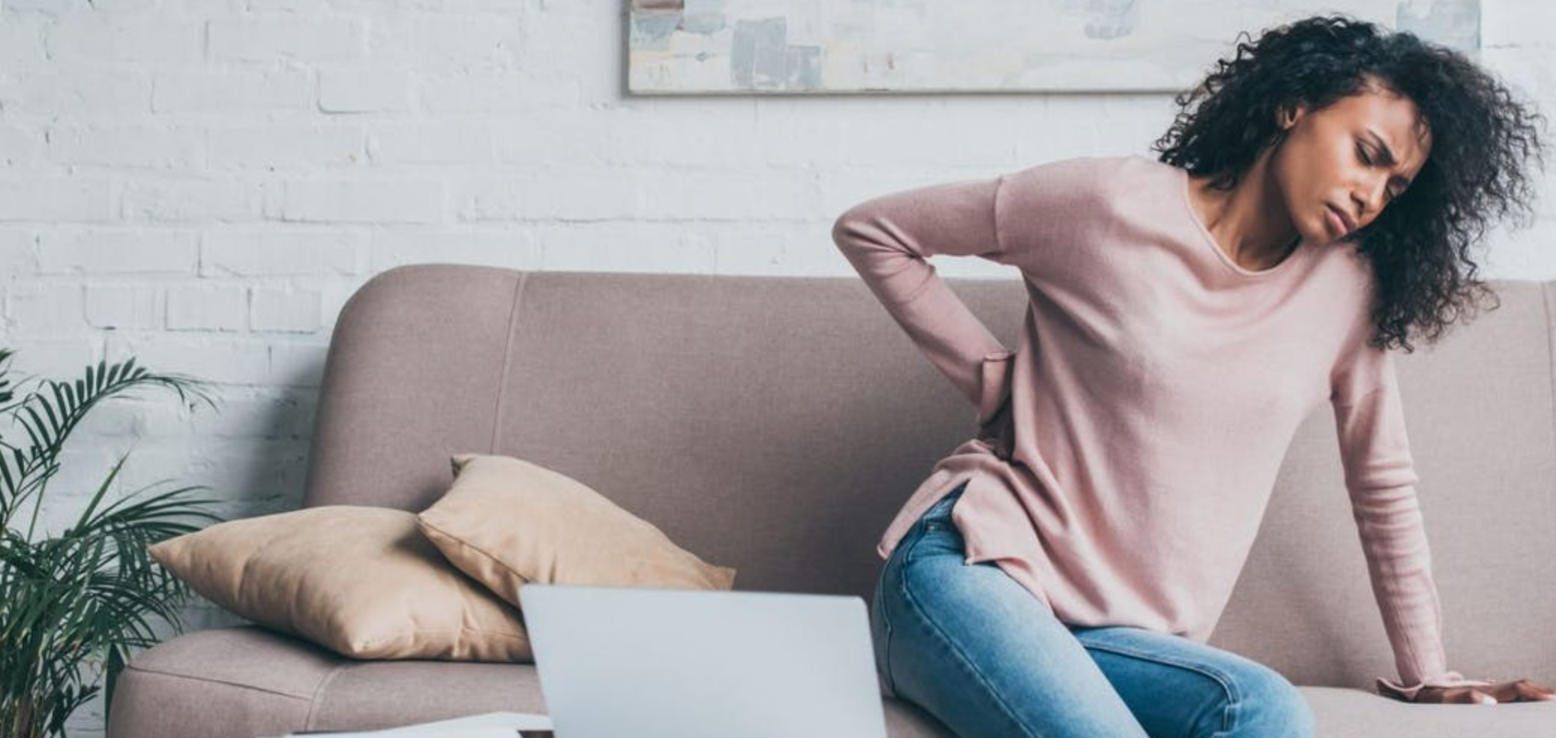 woman holding back while sitting