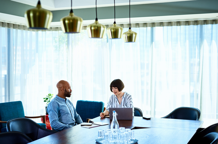 two people sitting at a large conference table