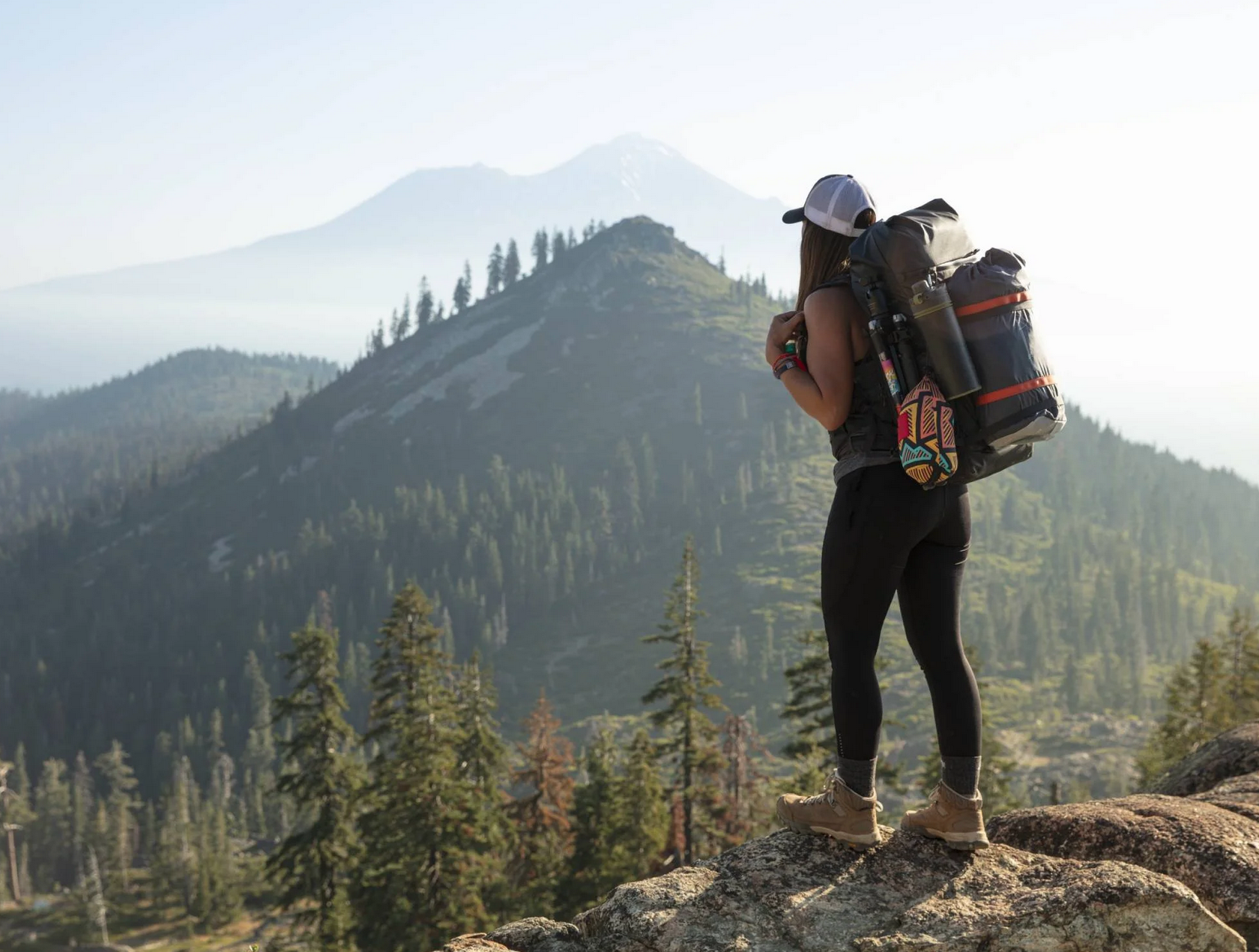 a person hiking with a backpack, looking at mountains