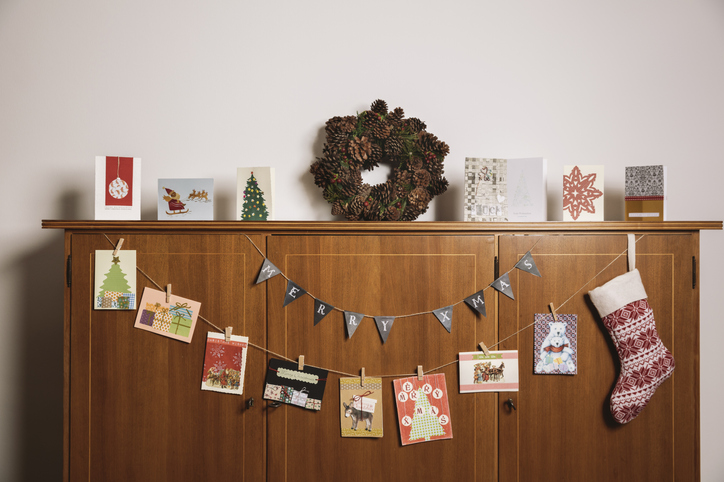 a cabinet with holiday decor and cards strung up