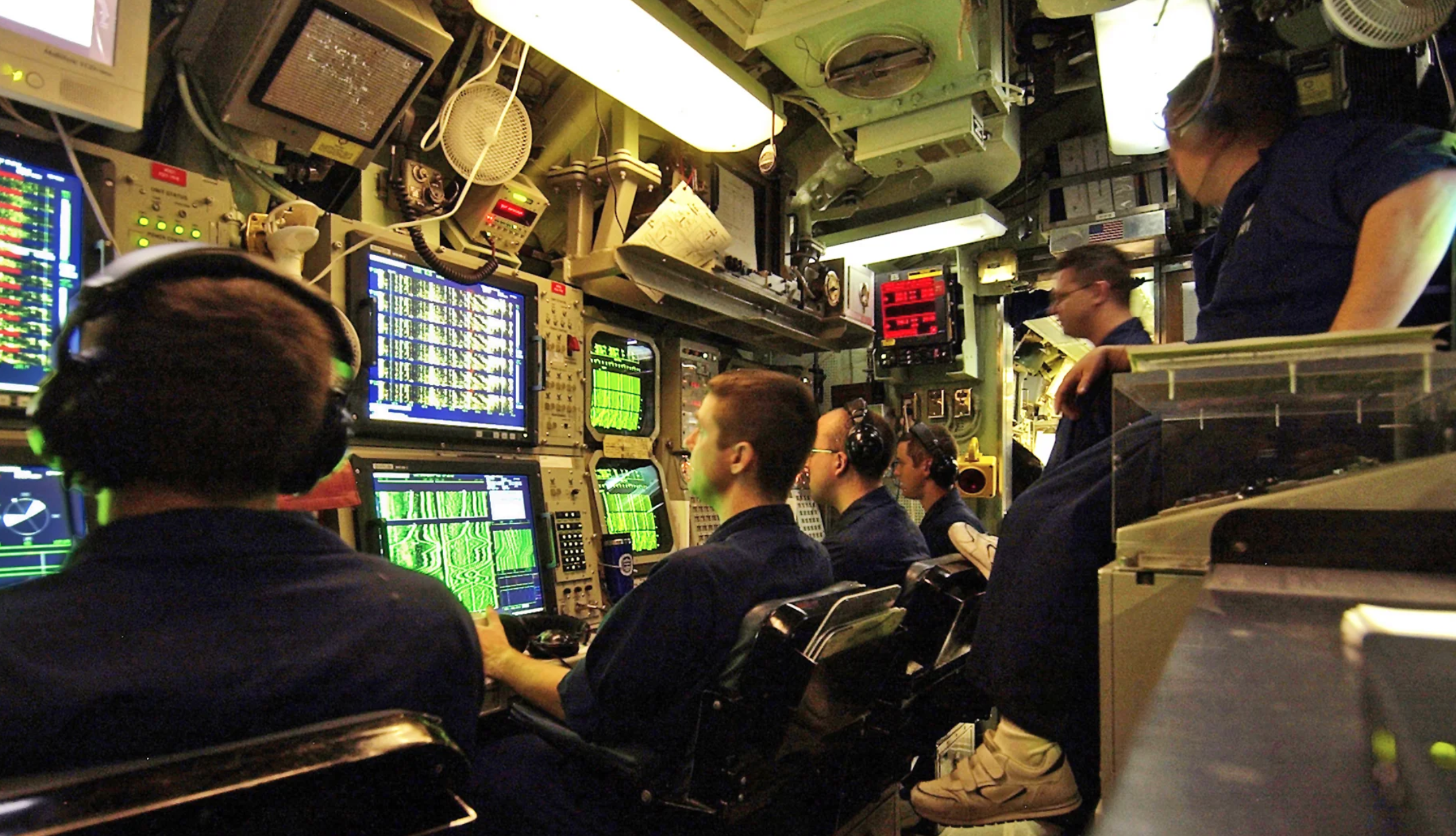 men staring at screens in a submarine