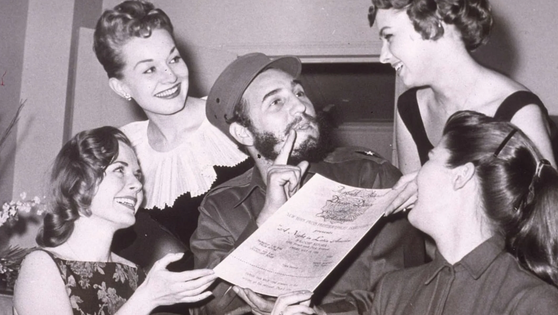 a smiling man surrounded by smiling women