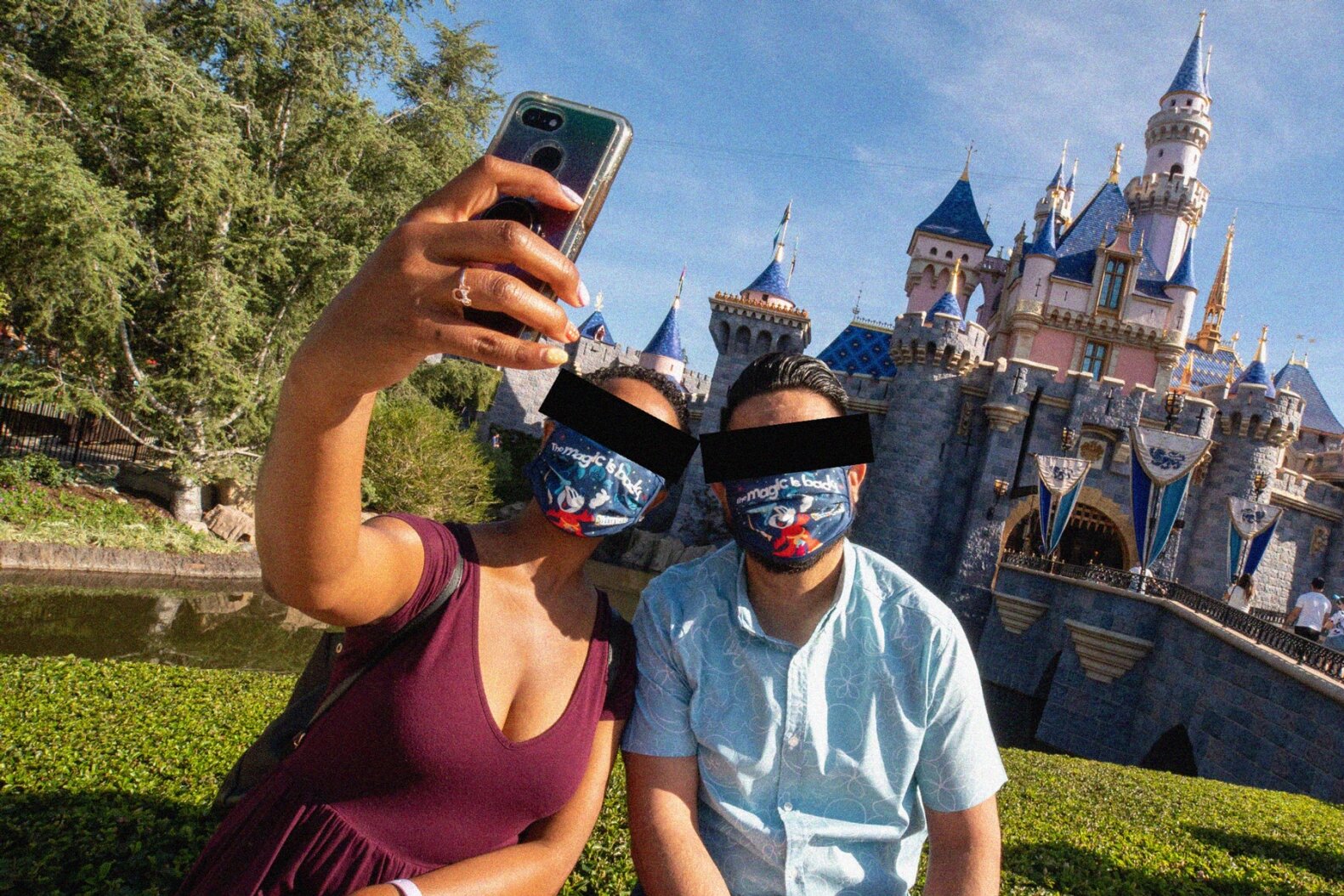 Two adults take a selfie outside of the castle at Disneyland