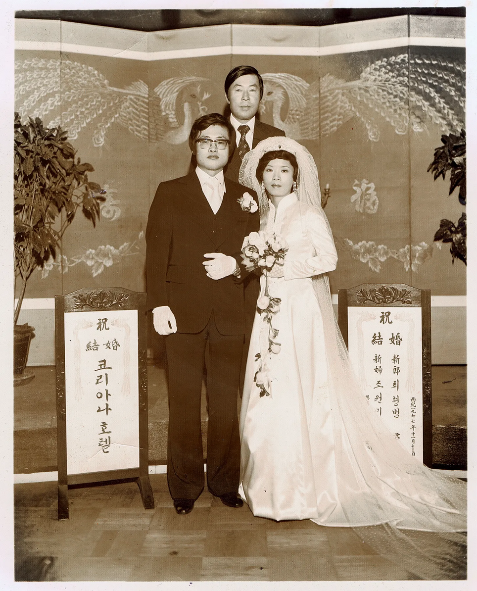 a couple and a man standing at a wedding altar