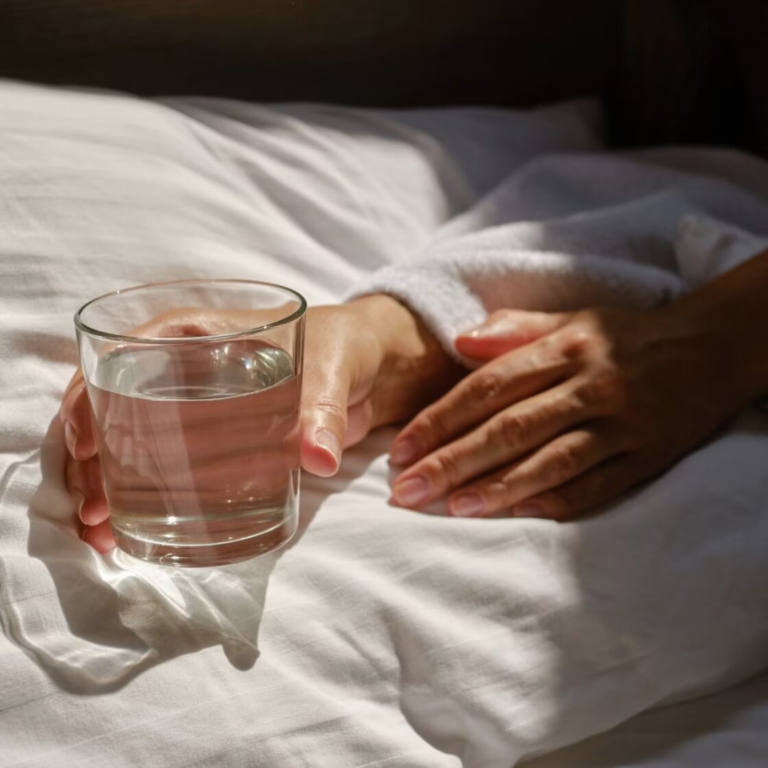 Hands holding a glass of water