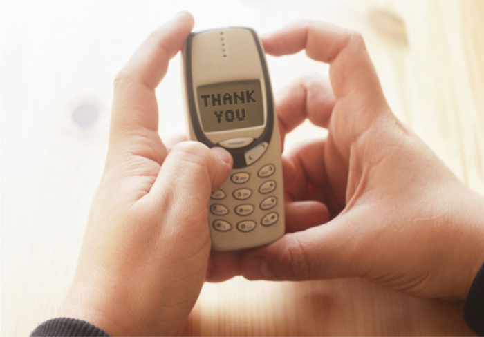 hands holding an old Nokia that says "THANK YOU" on the screen