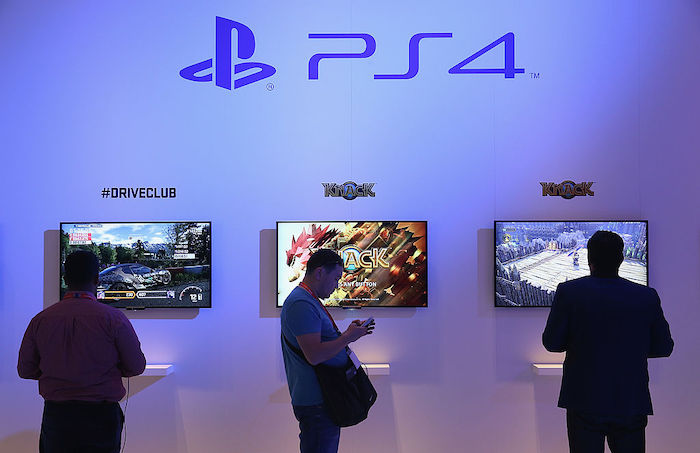 attendees at a trade fair try out the PS4 in 2013.