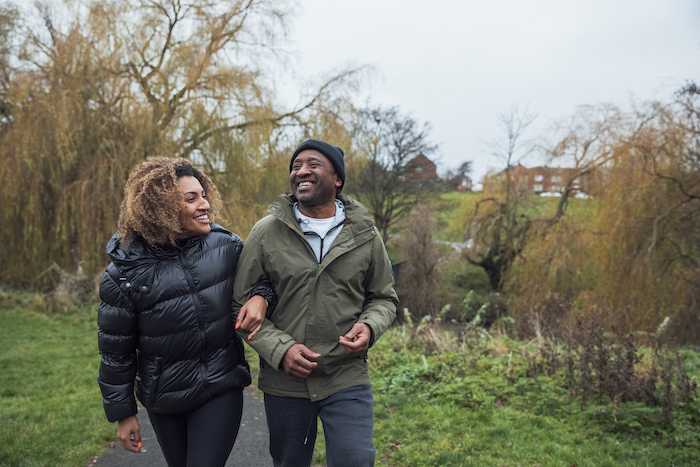 woman and older man walking down walking path
