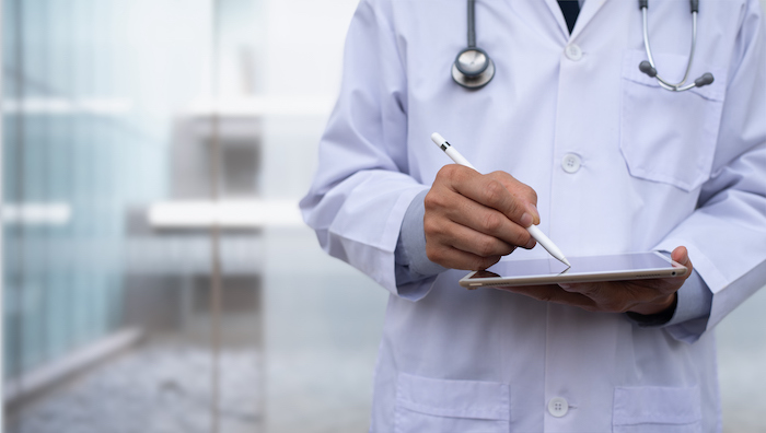 doctor writing on tablet